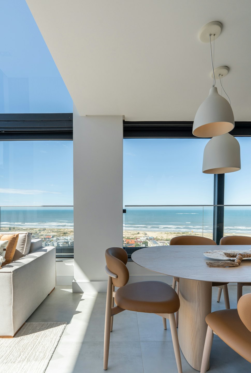 Espace de vie d'appartement moderne avec vue sur l'océan et la ville côtière.
